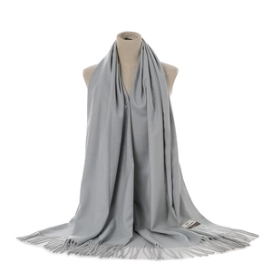 Grey cashmere feel winter fringe scarf close-up detail shot, elegant warm accessory.