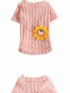 Detailed view of pink knitted dog sweater featuring yellow sunflower patch and cable textures