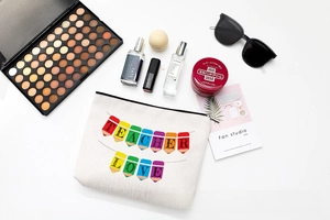 Flat lay of teacher-themed cotton canvas makeup bag with colorful pencil graphics