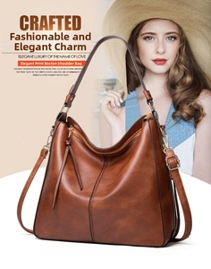 Detail of caramel brown tote bag featuring lychee grain leather and tassel charm