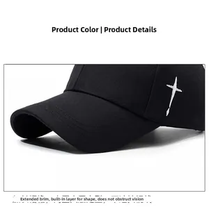 Detail view of the black baseball cap featuring a white cross embroidery and long brim