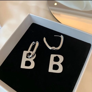 Close-up of silver letter B hoop earrings presented in a black velvet jewelry gift box