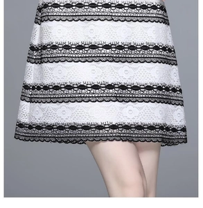 Close-up of black horizontal stripes on white lace dress with intricate embroidery