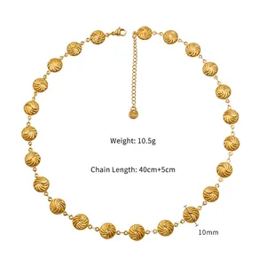 Macro view of golden sun-etched charms on stainless steel necklace with size specifications