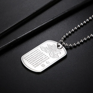 Macro shot of silver stainless steel lotus pendant with engraved Heart Sutra scripture