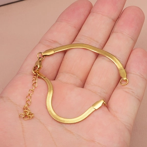 Elegante bracciale a catena a serpente dorato in mano con design minimalista a maglie