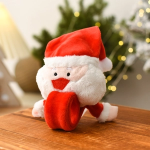 Macro detail of plush Santa Claus slap bracelet on a rustic wood surface with warm bokeh