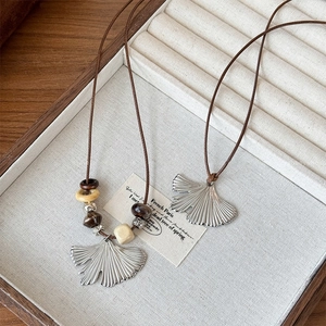 Ginkgo leaf pendant necklace in stainless steel with brown cord and beaded accents
