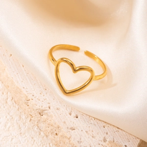Detail of an 18K gold plated heart-shaped open ring placed on stone and silk