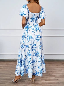 Dettaglio dell'elegante abito a fiori con gonna a balze, schiena arricciata e maniche a sbuffo