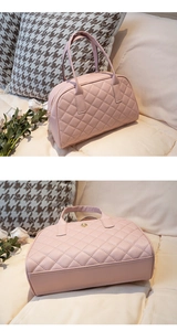 Détail du sac à main matelassé rose avec coutures en losange et emblème doré