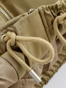 Vue macro détaillée de la fermeture éclair métallique et du cordon sur le manteau olive