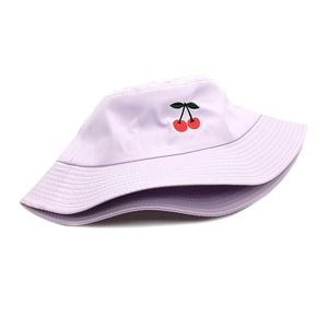 Close-up of red cherry embroidery and canvas texture on a lavender bucket hat