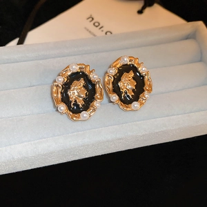 Detail of vintage French gold stud earrings featuring portrait relief and pearls