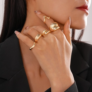 Detailansicht von fünf unregelmäßigen goldenen Ringen im Liquid-Metal-Design für Damen als Set