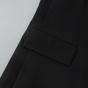 Detail shot of a black blazer's pocket flap showing the premium twill fabric texture