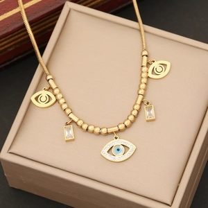 Macro detail of gold evil eye and square turquoise pendant necklace on gift box