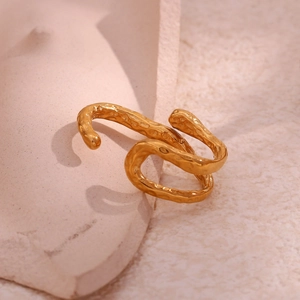 Macro detail of gold-plated stainless steel ring featuring irregular hammered texture surface