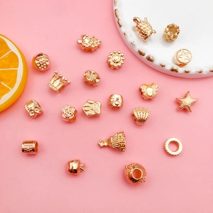 Macro shot of assorted golden alloy beads in crown and shell shapes for DIY jewelry