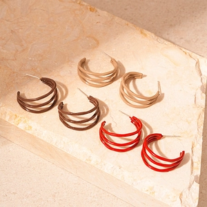 Detail view of multi-layer C-shaped hoop earrings in brown, nude, and red lacquer finish