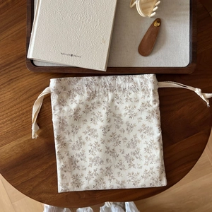 Detailed close-up of floral cotton drawstring pouch with rustic vintage texture