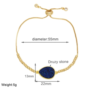 Macro view of gold adjustable bracelet with teardrop blue druzy stone and slider bead clasp