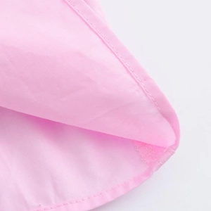 Dettaglio ravvicinato della trama del tessuto rosa e delle cuciture precise del set casual