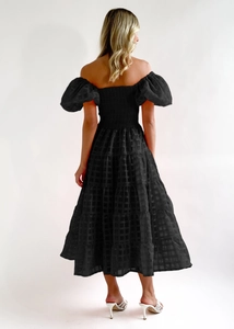 Back view of black off-shoulder dress featuring layered cake skirt and puff sleeves
