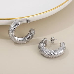 Detailed view of silver C-shaped hoop earrings with unique scale texture finish