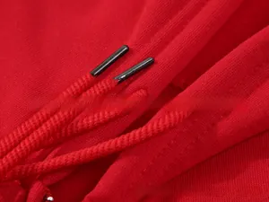 Detailed macro view of red hoodie fabric texture with drawstring and matte black ends