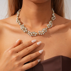 Détail du collier de perles et strass sur base en métal doré porté par un mannequin