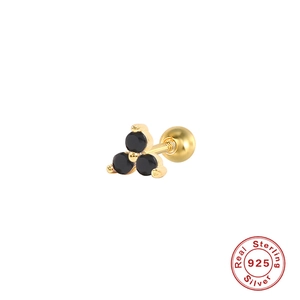 Macro shot of 925 sterling silver gold earring with three black stones in a triangle