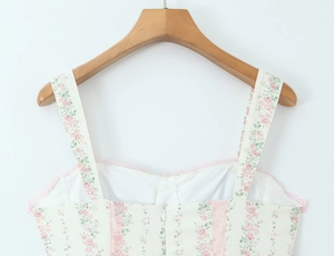 Dettaglio della stampa floreale rosa con bordo in pizzo sul vestito crema