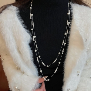 Detail of elegant double-layered pearl necklace with crystal balls on a black turtleneck