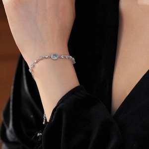 Close-up of elegant silver bracelet with oval light blue gemstone and zircon on wrist