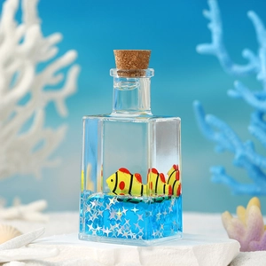 Macro detail of nautical fluid drift bottle with floating cartoon fish and blue liquid