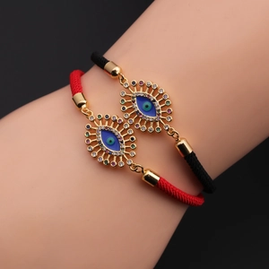 Dettaglio di braccialetti regolabili malocchio con zircone blu su corde intrecciate