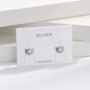 Macro view of S925 sterling silver fan-shaped stud earrings with white opal inlay