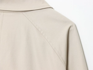 Dettaglio delle doppie cuciture premium su spalla e scollatura del trench color kaki