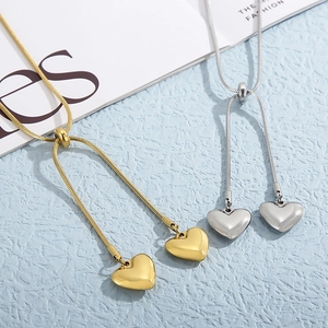 Minimalist gold and silver heart pendant necklaces with adjustable snake chains on blue