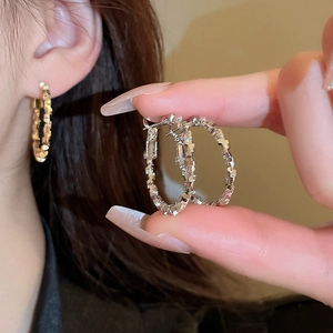 Detail of silver needle earrings featuring unique irregular crackle texture and metal shine