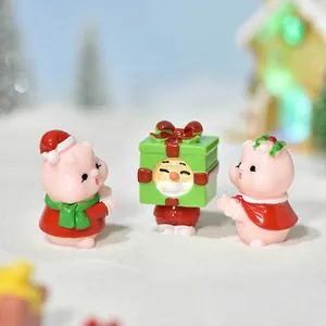 Three cute Christmas pig resin miniatures on artificial snow for micro landscape decor
