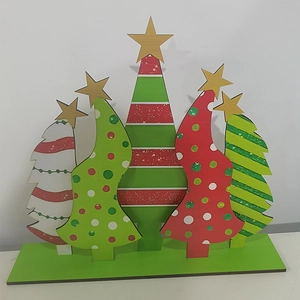 Detailed view of five handcrafted wooden Christmas trees with stars on green base