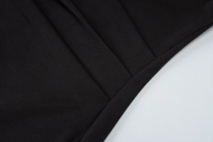 Detail of black fabric texture with visible stitching and draped folds on elegant dress