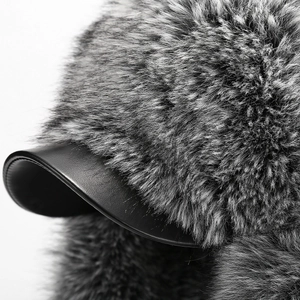 Macro shot of thick grey faux fur lining and black leather brim on a winter aviator hat