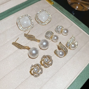 Detail view of 10-piece gold earring set with pearls and sparkling zircon in a jewelry box
