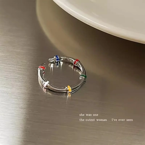 Detailed close-up of a silver bamboo-style open ring with multicolor stone accents
