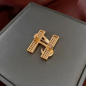 Broche luxueuse en forme de H dorée avec incrustation de zircon sur boîte à bijoux