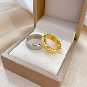 Minimalist matte titanium steel rings in gold and silver set in a beige jewelry box
