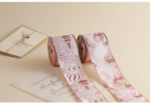 Macro detail of pink rose gold Christmas ribbons with glittery reindeer and snowflake patterns